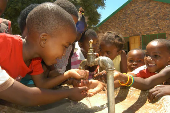 Kinderen drinken vers water uit een schoolkraan